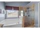 Modern bathroom with a soaking tub, a separate glass-enclosed shower, and stylish tile work at 2233 Sonoma Valley Dr, Charlotte, NC 28214