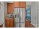 Kitchen features stainless refrigerator and wood cabinets with easy access to hardwood hallway at 2233 Sonoma Valley Dr, Charlotte, NC 28214
