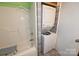 Bathroom highlighting a white tub, a stacked washer and dryer, and window at 2625 Glenn St, Newton, NC 28658