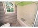 Bathroom showcasing a white tub with safety bars, alongside a window at 2625 Glenn St, Newton, NC 28658