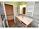 Bathroom featuring a white sink vanity with shelving, paired with wood paneled walls at 2625 Glenn St, Newton, NC 28658