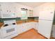 Bright kitchen featuring white cabinets and appliances plus light-colored countertop and flooring at 2625 Glenn St, Newton, NC 28658