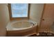 This bathroom features a soaking tub with a window to allow natural light to enter at 3208 Barons Court Rd, Charlotte, NC 28213