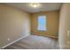 This bedroom has neutral paint and carpet with a window at 3208 Barons Court Rd, Charlotte, NC 28213