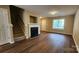 Spacious living room with fireplace, staircase, hardwood floors and natural light from the front window at 3208 Barons Court Rd, Charlotte, NC 28213