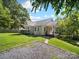 Quaint single story home with a cozy porch, side yard, and gravel area at 322 Peachtree St, Albemarle, NC 28001