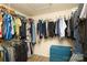 Walk-in closet features metal shelving and a variety of hanging clothes with a small blue dresser at 4001 Brook Valley Run, Monroe, NC 28110