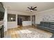Open-concept living room features fireplace, hardwood floors, modern furnishings, and a ceiling fan at 4001 Brook Valley Run, Monroe, NC 28110