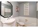 A stylish powder room featuring gray walls, a decorative mirror and half wall wainscoting at 4001 Brook Valley Run, Monroe, NC 28110