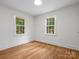 Light-filled bedroom features hardwood floors and large windows for ample natural light at 4126 Howie Cir, Charlotte, NC 28205