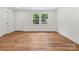 Bright living room featuring refinished wood floors, fresh paint, and updated lighting at 4126 Howie Cir, Charlotte, NC 28205