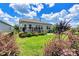 Backyard featuring lush green grass, plants, a black metal fence, a stone patio, and a cozy deck at 4197 Canopy Creek Dr, Denver, NC 28037