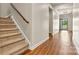 Inviting foyer with wood floors, staircase, and natural light streaming in from the open front door at 4197 Canopy Creek Dr, Denver, NC 28037