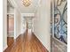 Inviting home hallway with rich hardwood flooring and decorative light fixture, leading to the living areas at 4197 Canopy Creek Dr, Denver, NC 28037