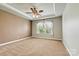 The spacious main bedroom features a tray ceiling, a ceiling fan, plush carpet, and large windows at 4197 Canopy Creek Dr, Denver, NC 28037