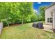 Grassy backyard with mature trees and a grill at 424 Castlebury Ct, Clover, SC 29710