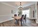 Bright dining room with modern chandelier, wood-style floors, and large window at 424 Castlebury Ct, Clover, SC 29710
