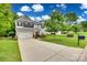 Well-maintained two-story home with a long driveway, a large lawn, and mature landscaping at 424 Castlebury Ct, Clover, SC 29710