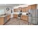 Well-lit kitchen featuring stainless steel appliances, wooden cabinets, granite countertops, and hardwood floors at 424 Castlebury Ct, Clover, SC 29710