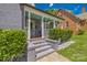 Home featuring a covered front porch, lush landscaping, and gray painted brick at 432 4Th Street Sw Pl, Hickory, NC 28602