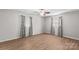 Light-filled bedroom featuring hardwood flooring and two windows with decorative curtains at 44092 Woodhurst Rd, New London, NC 28127