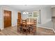 Cozy dining area with wood table, new floors, and natural light from the window at 44092 Woodhurst Rd, New London, NC 28127