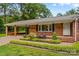 Well-maintained brick house with a connected carport and manicured landscaping at 44092 Woodhurst Rd, New London, NC 28127