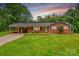 Charming single-story brick home with a well-manicured lawn and a covered carport at 44092 Woodhurst Rd, New London, NC 28127