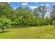 Scenic front yard view with lush lawn, mature trees and landscaped surroundings at 44092 Woodhurst Rd, New London, NC 28127
