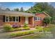 Charming brick home with a landscaped front yard featuring lush greenery and a welcoming entrance at 44092 Woodhurst Rd, New London, NC 28127
