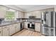 Updated kitchen features granite counters, stainless steel appliances, and decorative backsplash at 44092 Woodhurst Rd, New London, NC 28127