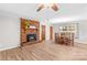 Living room area with a brick fireplace and new flooring, connected to the dining area at 44092 Woodhurst Rd, New London, NC 28127