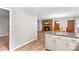 Open concept living room with wood flooring, a brick fireplace, and a clear view into the kitchen at 44092 Woodhurst Rd, New London, NC 28127