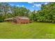 View of back of brick house and luscious green grass and yard at 44092 Woodhurst Rd, New London, NC 28127