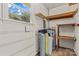 Utility room featuring water heater, water softener, and shelving at 44092 Woodhurst Rd, New London, NC 28127