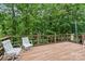 Relax on the spacious deck surrounded by lush greenery and comfortable striped chairs at 460 27Th Avenue Nw Cir, Hickory, NC 28601