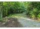 A long driveway with a metal covered area for parking, surrounded by lush greenery and trees at 460 27Th Avenue Nw Cir, Hickory, NC 28601