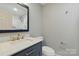 Modern bathroom with a vessel sink, gray vanity, and a tiled shower, offering a sleek and stylish design at 4838 Keats Ave, Charlotte, NC 28212
