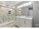 This bathroom boasts a glass shower, marble tile, and a double sink vanity for a spa-like experience at 4838 Keats Ave, Charlotte, NC 28212