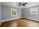 Bright bedroom with hardwood floors, two windows offering natural light, and a ceiling fan for added comfort at 4838 Keats Ave, Charlotte, NC 28212