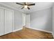 Spacious bedroom with hardwood floors, a large closet, and a ceiling fan, providing comfort and convenience at 4838 Keats Ave, Charlotte, NC 28212