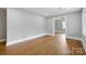 Spacious living room with hardwood floors, light gray walls, white trim, and a view into an adjacent room with plenty of natural light at 4838 Keats Ave, Charlotte, NC 28212