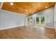 The room features a stunning wood ceiling, complemented by gleaming hardwood floors and natural light streaming in through French doors at 4838 Keats Ave, Charlotte, NC 28212