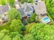 Aerial view showcasing a home with a landscaped backyard, fire pit, and in-ground pool at 5518 Morris Hunt Dr, Fort Mill, SC 29708