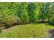 Lush backyard with well-maintained landscaping, mature trees, and a swing, perfect for outdoor enjoyment at 5518 Morris Hunt Dr, Fort Mill, SC 29708