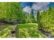 Spacious backyard featuring a lush lawn, mature trees, and tiered landscaping, creating a serene outdoor space at 5518 Morris Hunt Dr, Fort Mill, SC 29708