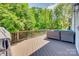 Inviting deck featuring a gray wicker sofa, overlooking a serene wooded area, perfect for outdoor relaxation at 5518 Morris Hunt Dr, Fort Mill, SC 29708