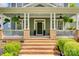 Inviting front porch with brick accents, white columns, and lush greenery, perfect for relaxing at 5518 Morris Hunt Dr, Fort Mill, SC 29708
