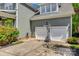 View of the two-car garage with white doors and a basketball hoop on the driveway at 5518 Morris Hunt Dr, Fort Mill, SC 29708