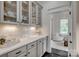 Charming butler's pantry features white cabinets, countertop, and shelves with beautiful views into the sunroom at 5518 Morris Hunt Dr, Fort Mill, SC 29708